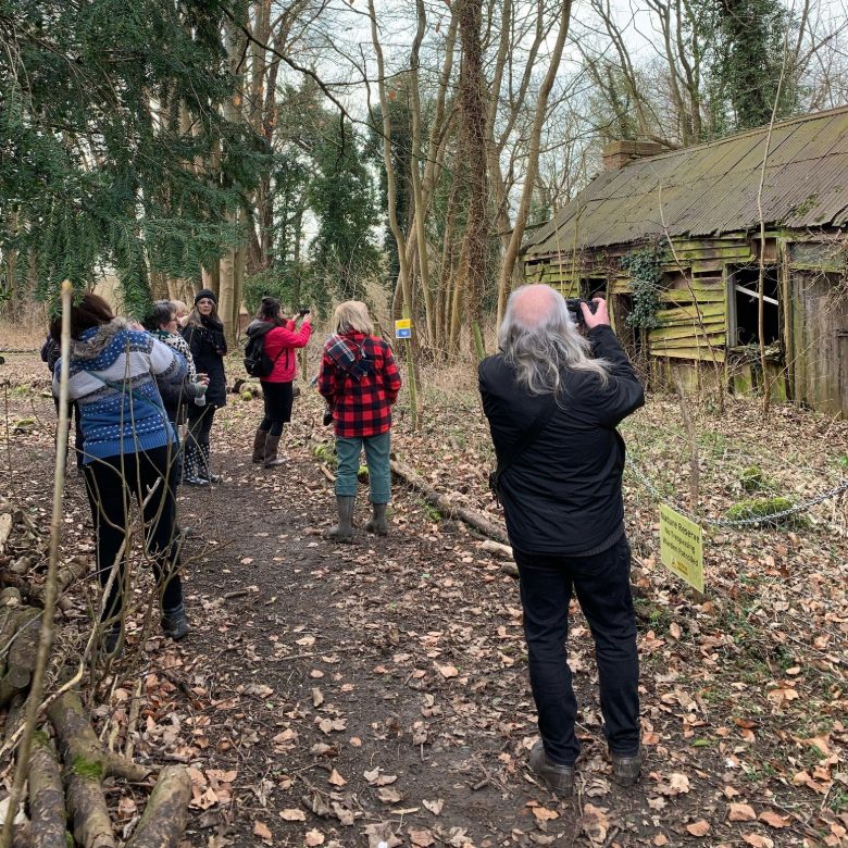 Tutors from the Oxfordshire Recovery Project just inside the reserve entrance, looking at the old blacksmith's forge.